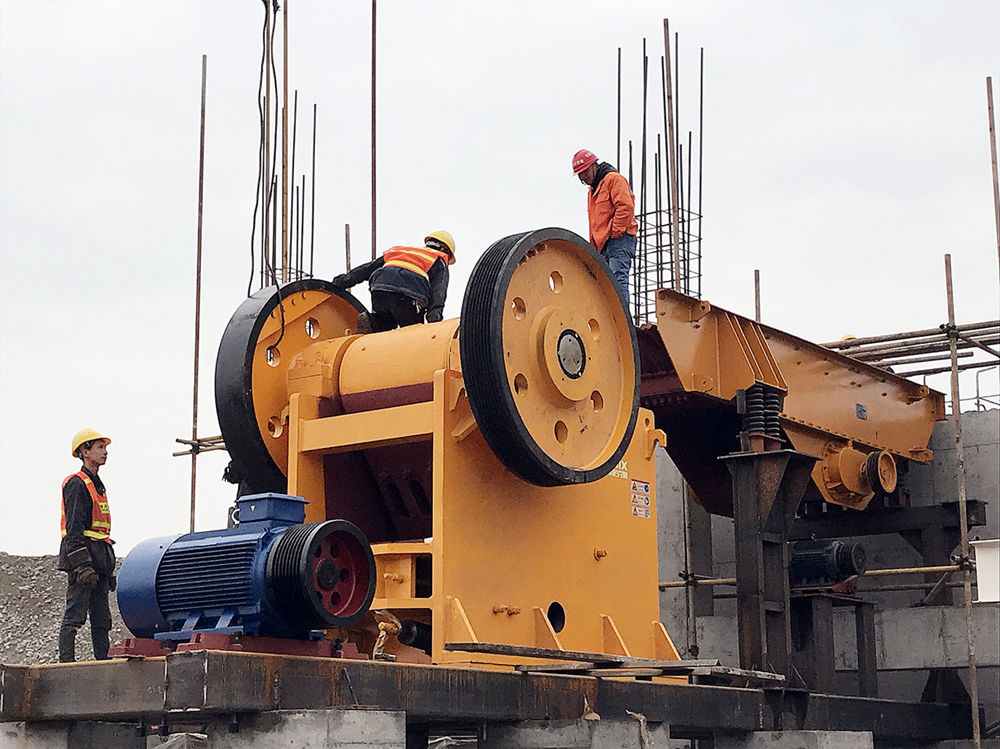 兩臺(tái)PE750顎式破碎機(jī)和喂料機(jī)在現(xiàn)場進(jìn)行緊張安裝中